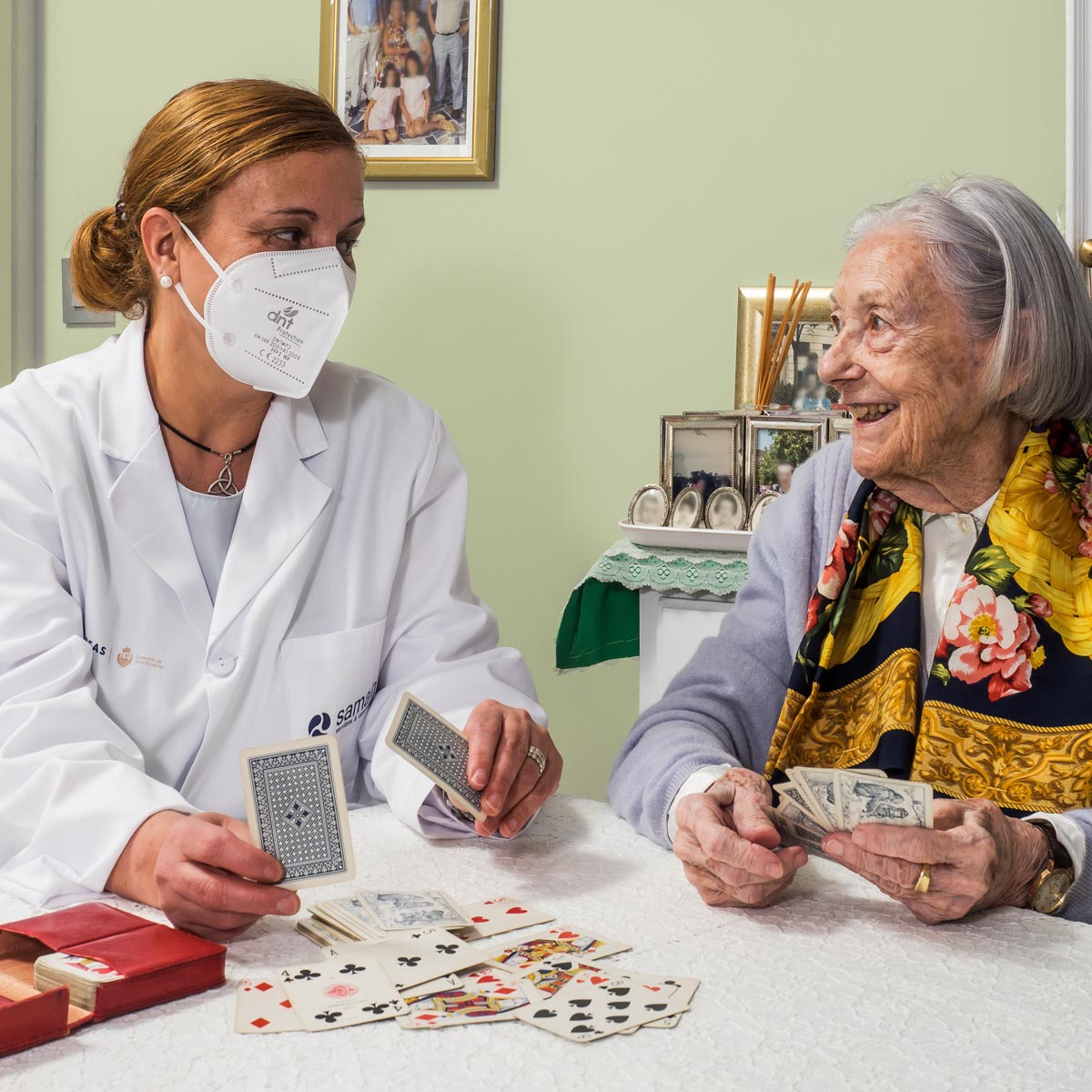 Una trabajadora de Samaín jugando a las cartas con una residente